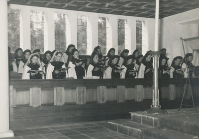 879214 Groepsportret van zingende Zusters Augustinessen, tijdens de wijding van 'nieuwe' Zusters Augustinessen (links ...